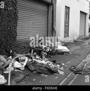 La spazzatura e spazzatura a sinistra in Cardiff back street, autorità locali non hanno le risorse per eliminare. Il 14 aprile 2016 Foto Stock