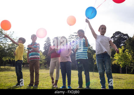 Dei bambini felici giocando con palloncini nel parco Foto Stock