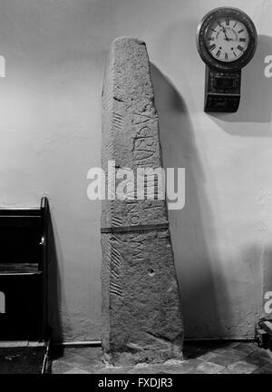 All'interno della chiesa di San Tommaso a St Dogmaels, Pembrokeshire, a C5A/C6th pilastro di pietra con iscrizioni in latino sulla faccia & ogham (ogam) sul bordo sinistro. Foto Stock