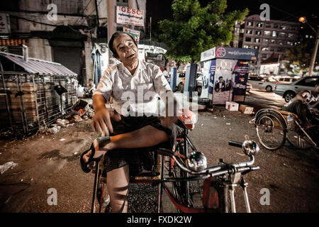 Myanmar, citta' di Yangon, un uomo nella città di notte sul risho ridendo. Foto Stock