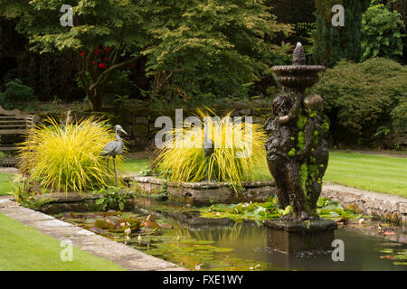 Una bella, privato tradizionale, paesaggistico, country Garden, West Yorkshire, Inghilterra - laghetto ornamentale, fontana e graminacee. Foto Stock