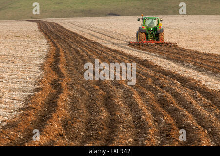 Il trattore arare un campo del South Downs, East Sussex, Inghilterra. Foto Stock