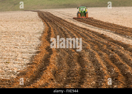 Il trattore arare un campo del South Downs, East Sussex, Inghilterra. Foto Stock
