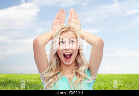 Sorridenti giovane donna fare orecchie di coniglietto Foto Stock