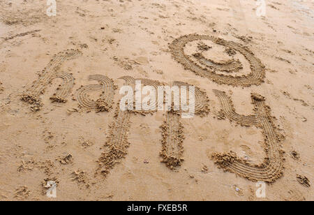La parola scritta felice sulla spiaggia di Camber Sands, segala, East Sussex, Regno Unito Foto Stock