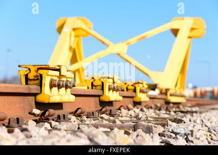 Di colore giallo brillante Treno fermata tampone paraurti o alla fine di un binario ferroviario. Foto Stock