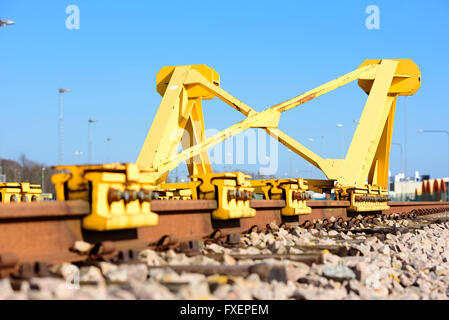 Di colore giallo brillante Treno fermata tampone paraurti o alla fine di un binario ferroviario. Foto Stock