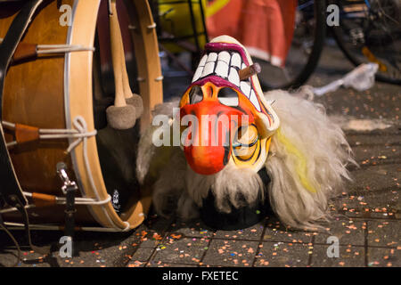 Chiudere la vista su uno grinning Basilea maschera di Carnevale posa su strada oltre a un grande tamburo. Foto Stock