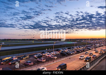 Traffico di sera al tramonto come i viaggiatori arrivano a Atlanta International, il mondo aeroporto più trafficato, in auto e in aereo. (USA) Foto Stock