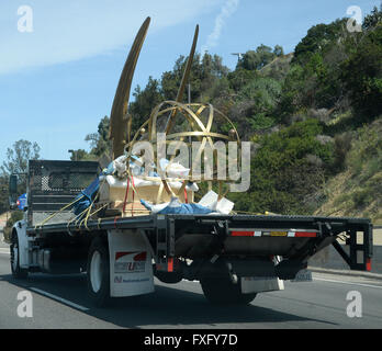 North Hollywood CA. Xv Apr, 2016. Il più grande del mondo di Emmy statuetta come fa il suo ora-lungo viaggio lungo la California Highway 101 da est di Los Angeles per la sua nuova casa a la Television Academy di North Hollywood campus. A quasi un anno di preparazione, il 18-piedi alti, 1750 pound golden Emmy replica raffigura l'alata musa dell' arte tenendo un atomo di elettroni. Cast in silicio puro bronzo, ella era faticosamente creato da 45 artigiani separato. Credito: ZUMA Press, Inc./Alamy Live News Foto Stock