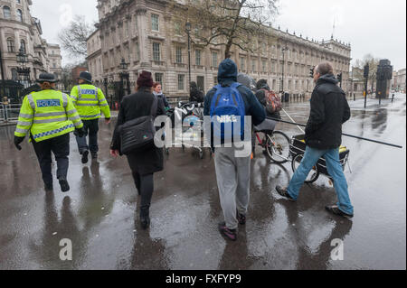 Londra, Regno Unito. Il 15 aprile, 2016. Azione diretta strade di gruppo cucina che che supporta senzatetto sulle strade di Londra si sposta alla Whitehall per un rally e di silenzio in memoria di coloro che sono morti a Downing St prima di marciare sotto la pioggia intorno al centro di Londra in solidarietà con Londra crescente della comunità senza tetto. Essi hanno portato tende, sacchi a pelo e cibo che intendono aderire al uccidere l'alloggiamento Bill sleepout a Southwark e raccolto donazioni. Peter Marshall / Alamy Live News Foto Stock