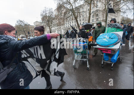 Londra, Regno Unito. Il 15 aprile, 2016. Azione diretta strade di gruppo cucina che che supporta senzatetto sulle strade di Londra si sposta alla Whitehall per un rally e di silenzio in memoria di coloro che sono morti a Downing St prima di marciare sotto la pioggia intorno al centro di Londra in solidarietà con Londra crescente della comunità senza tetto. Essi hanno portato tende, sacchi a pelo e cibo che intendono aderire al uccidere l'alloggiamento Bill sleepout a Southwark e raccolto donazioni. Peter Marshall / Alamy Live News Foto Stock