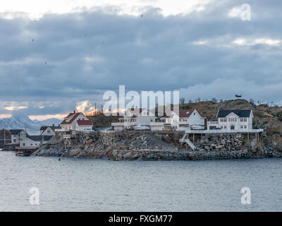 Nuvole al tramonto su case in Henningsvaer su Austvagoy, Isole Lofoten Norvegia settentrionale, Scandinavia Foto Stock