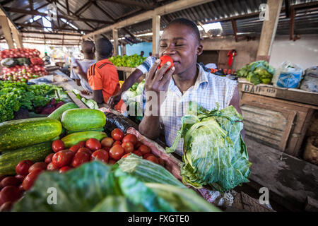 Mozambico, Africa, un uomo vendere verdure al mercato nella città. Foto Stock