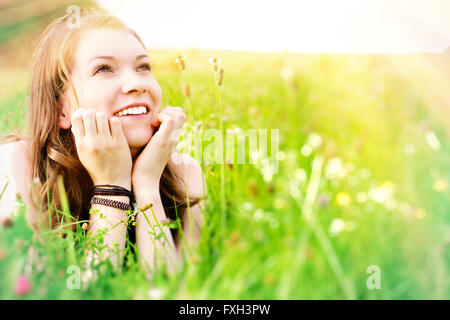 Giovane donna felice posa su un prato Foto Stock