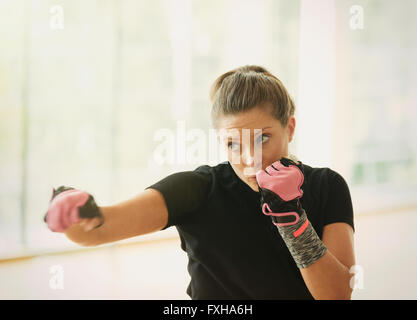 Donna con guanti di esercizio shadow boxing Foto Stock