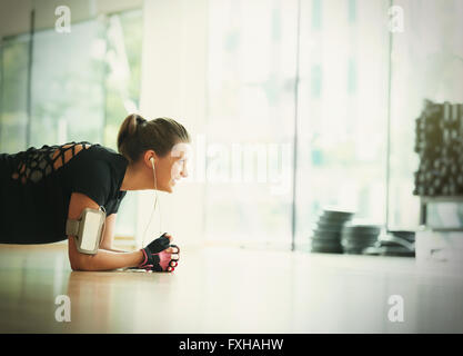 Donna sorridente nella posizione dell'asse sulle palestra studio piano Foto Stock