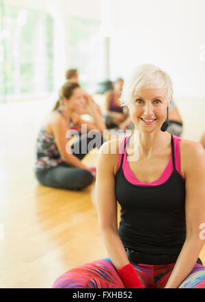 Ritratto sorridente istruttore di fitness con cuffia Foto Stock