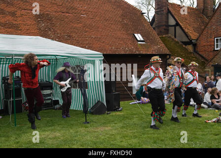 In cerca di attenzione, stile musicale contrastante, Morris Dancing e a Glam Rock Band suonano contemporaneamente. Pub Garden 1° maggio festa del villaggio. Il giardino del pub Perch and Pike. South Stoke Berkshire, Inghilterra anni '2006 2000 UK HOMER SYKES Foto Stock