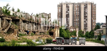 Blocco di appartamenti cassonetto e rovine di Novo Sarajevo. Foto Stock