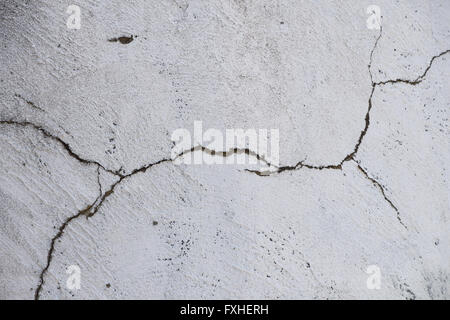 Danni split crack in bianco gesso dipinto muro di cemento sullo sfondo Foto Stock