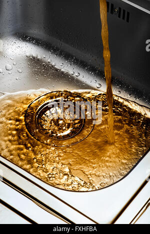 Lavandino versando acqua sporca, di acqua e di goccioline Foto Stock