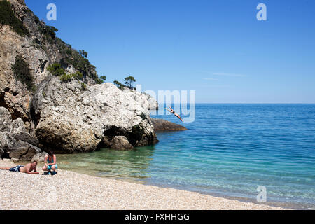 Un uomo che si tuffa nel mare di Porto Greco spiaggia vicino vieste puglia, Italia Foto Stock