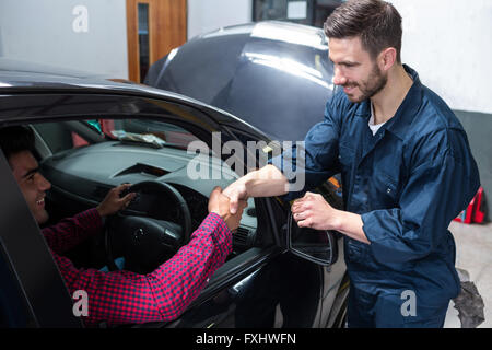 Il cliente si stringono la mano con meccanico Foto Stock