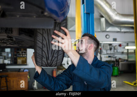 Esaminando meccanico pneumatico per automobile Foto Stock