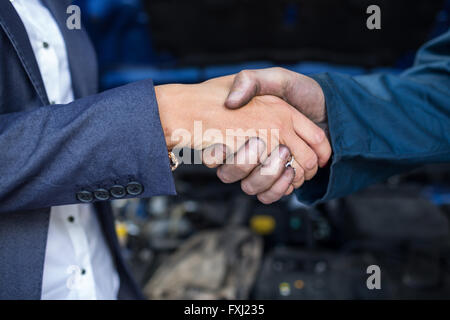 Il cliente si stringono la mano con meccanico Foto Stock