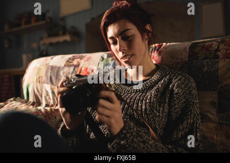 Giovane donna che guarda la sua fotocamera Foto Stock