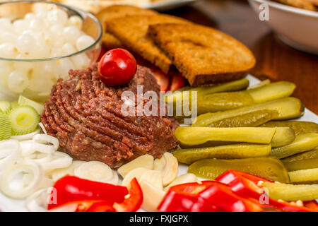 Carne di manzo crudo tartare di manzo con cipolla e pane tostato Foto Stock