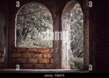 Porta ad arco e aperture a finestra in una vecchia casa di pietra calcarea Foto Stock