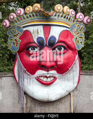 Un grande oriental faccia rossa con la corona sulla parete Foto Stock