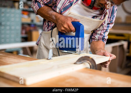 Carpenter usando un seghetto alternativo Foto Stock