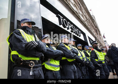 Londra, Regno Unito. 16 Aprile, 2016. Gli ufficiali di polizia bloccare l'ingresso del ramo del filamento di Topshop nel corso di una protesta da parte di militanti dal sindacato United voci del mondo e i membri della classe guerra alla chiamata per la reintegrazione del 'Topshop 2', due pulitori contratta per il Britannia gruppo di servizi che sono stati sospesi dopo che hanno aderito a un sindacato e hanno protestato contro i loro salari. Regno voci del mondo ha lanciato una campagna per un vivere a Londra salario di £9.40 a Topshop nel febbraio 2016. Credito: Mark Kerrison/Alamy Live News Foto Stock