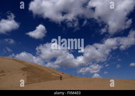 Jiuquan, la Cina della provincia di Gansu. Xvi Apr, 2016. La gente visita il Crescent Lake scenario spot in montagna Mingsha di Dunhuang City, a nord-ovest della Cina di Provincia di Gansu, Aprile 16, 2016. Dunhuang City ha dimostrato la sua naturale bellezza dopo una pioggia di Sabato. Credito: Zhang Xiaoliang/Xinhua/Alamy Live News Foto Stock