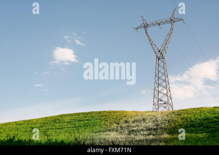 Inquinamento Elettromagnetic del pilone sulla collina verde Foto Stock