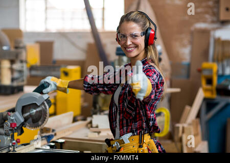 Ritratto di donna falegname che mostra pollice in alto Foto Stock