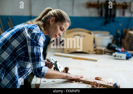 Falegname femmina il livellamento di un legno con piano di presa Foto Stock