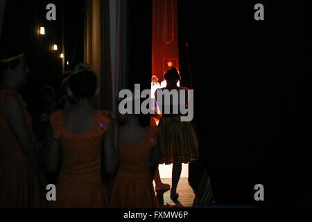 Dietro le quinte, ballerini guarda lo spettacolo al backstage attraverso la tenda mentre attendere per entrare nella fase. Foto Stock