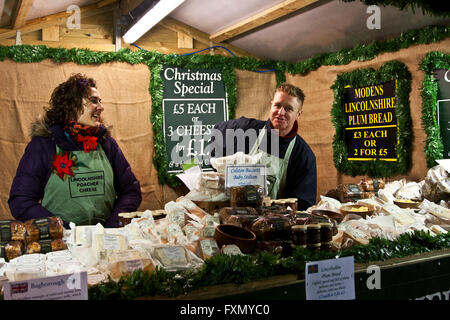 Mercatino di Natale di Lincoln, Lincolnshire, Inghilterra, Lincolnshire Bracconiere fornitori di formaggio nel loro stand alla fiera. Foto Stock