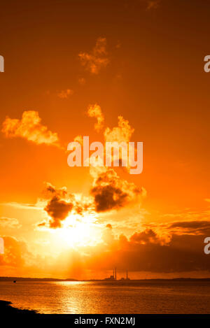 Arancione tramonto su una stazione di alimentazione sul fiume Shannon in Irlanda Foto Stock