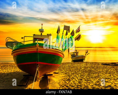 Il pittoresco paesaggio di un alba con una barca sulla spiaggia di Sopot, Polonia. Foto Stock