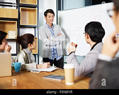 Giovani asiatici business executive facilitando una discussione Foto Stock