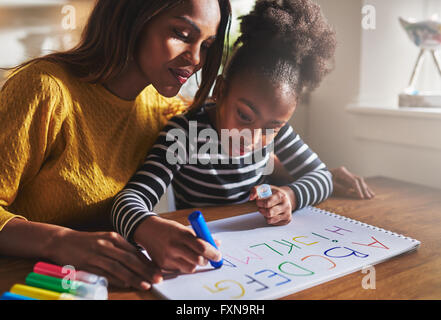 Bambina iscritto l'alfabeto con la madre a casa