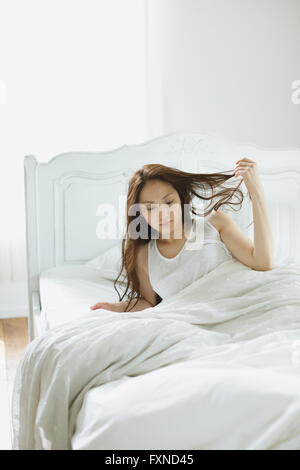 Attraente giovane donna giapponese a letto Foto Stock