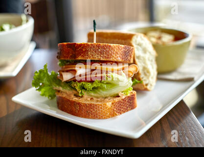 Sandwich di tacchino con pancetta e formaggio, lattuga e pomodoro mayonaise su pane di grano con zuppa Foto Stock