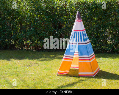 Colorati bambino giocattolo tenda teepee dei nativi americani realizzata in tela sull'erba in una giornata di sole Foto Stock