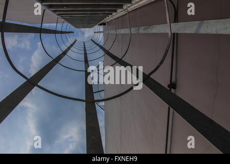 Scala sul tetto di un edificio alto con una vista del ritorno dal basso verso l'alto. Foto Stock